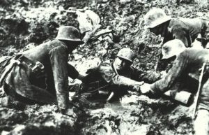 German troops trying to rescue what looks like a French soldier from sinking in a mud hole. Northern France, 1914-1918. 