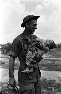 Staff Sergeant Edgar D. Bledsoe, of Olive Branch, Ill., cradles a critically ill Vietnamese infant brought to Fire Support Base Pershing, December 30, 1968.