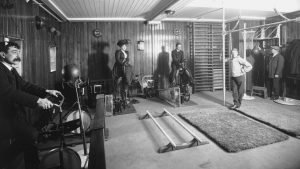 RMS Franconia gym, Edwardians bike-exercising in day clothes, 1911.