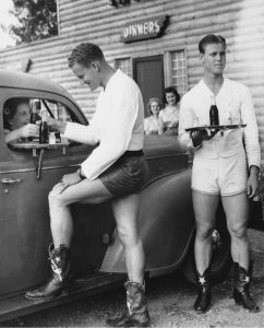 Men dressed in shorts and cowboy boots served up to women, Texas, 1940s.