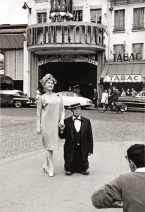 Buster Keaton and Hungarian beauty in front of the Moulin Rouge, 1959. 