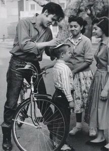 Elvis Presley signing autographs for kids in Memphis, 1950s.