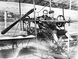 J.A.D. McCurdy at the wheel of the Silver Dart, with Glenn Curtiss behind him. The aircraft was the first powered, heavier-than-air machine to fly in Canada. (March, 1910)