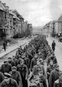 The endless procession of German prisoners captured with the fall of Aachen marching through the ruined city streets to captivity. October 1944 