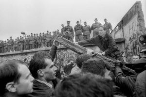 Protesters tear down the Berlin Wall as East German police watch. 1989 