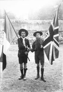 French and British scouts unite, flags in hands, 1912.