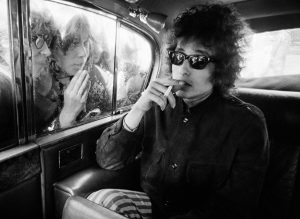 Fans peering into the window at Bob Dylan in a limousine, 1966.