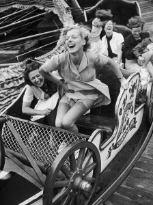 Wind lifts dress, carefree spirit in Southend Fair, UK, 1938.