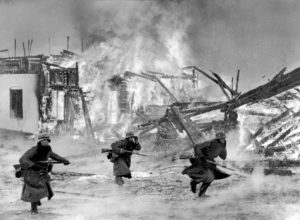 German troops move through a burning Norwegian village, 1940 