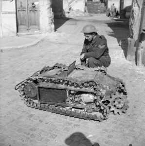 A soldier examines a captured German Goliath 
radio-controlled tracked demolition vehicle, Italy, 
12 April 1944 