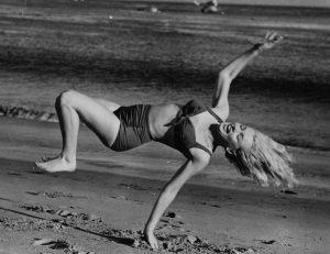 Marilyn Monroe frolicking on the beach near her Hollywood home. 1950s.
