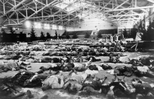 Victims of a bombing raid are laid out for identification and burial in a gymnasium, Berlin, December 1943 