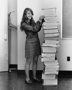 Margaret Hamilton, standing with a copy of the Apollo source code, 1969.