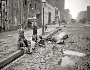 Kids play on the street, unbothered by a dead horse, NYC, 1905.
