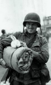 Soldier returns from France with rabbit mascot, England, 1944.