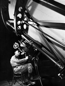 Astronomer Edwin Hubble gazes through Hooker telescope, 1937.