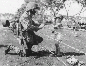 A Marine gives some food to a Japanese child on Saipan, 1944.