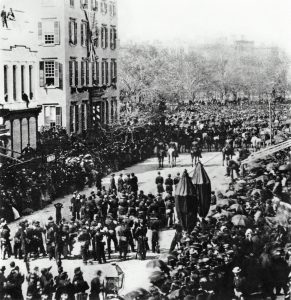 As Lincoln's funeral procession passes by, 7 yr old Teddy Roosevelt watches with his brother from the 2nd floor window of his grandfather's house (April 25, 1865)  