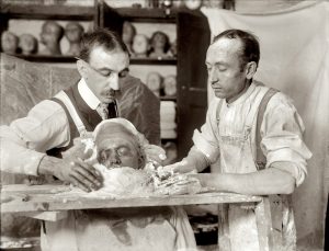 Two men crafting a death mask!