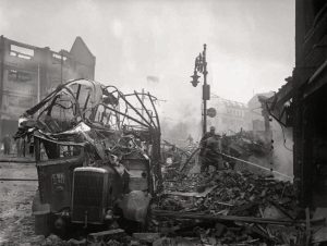 'A wrecked bus stands among a scene of devastation in the centre of Coventry after the major Luftwaffe air raid on the night of 14/15 November 1940' 