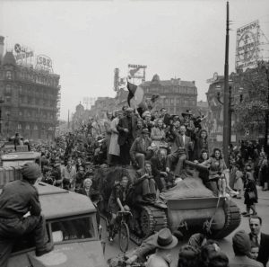 Civilians ride on a Sherman tank as British troops liberate Brussels, 4 September 1944 