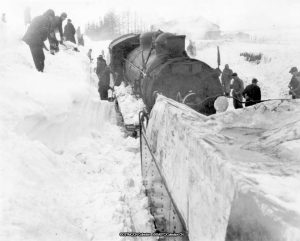 Steam train and snow clearing crews after a major snowfall in Canada circa 1950 