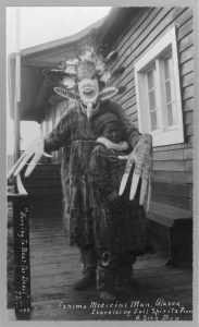 Eskimo shaman, known as a medicine man, healing sick boy, 1900s.