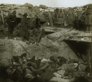 Russian soldiers looking down at a trench filled with corpses of Japanese soldiers, Port Arthur, ca.1905  