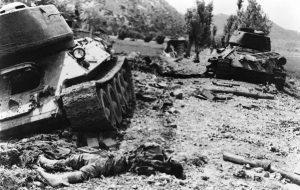 A North Korean tankman lies dead on ground amid knocked-out tanks in Indong, Korea, North of Waegwan, after South Korean attack, August 13, 1950. 