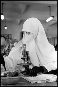 A fundamentalist student looks in a microscope in the biology lab, 1987.