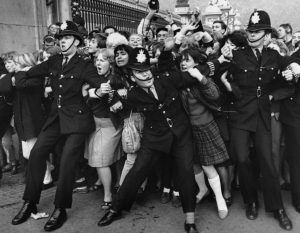 1965: Guards ensure Beatles' MBE, bar gate climbers.